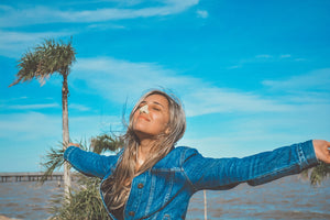 Woman embracing the outdoors while wearing a fun and colorful Nöz sunscreen product on her nose.